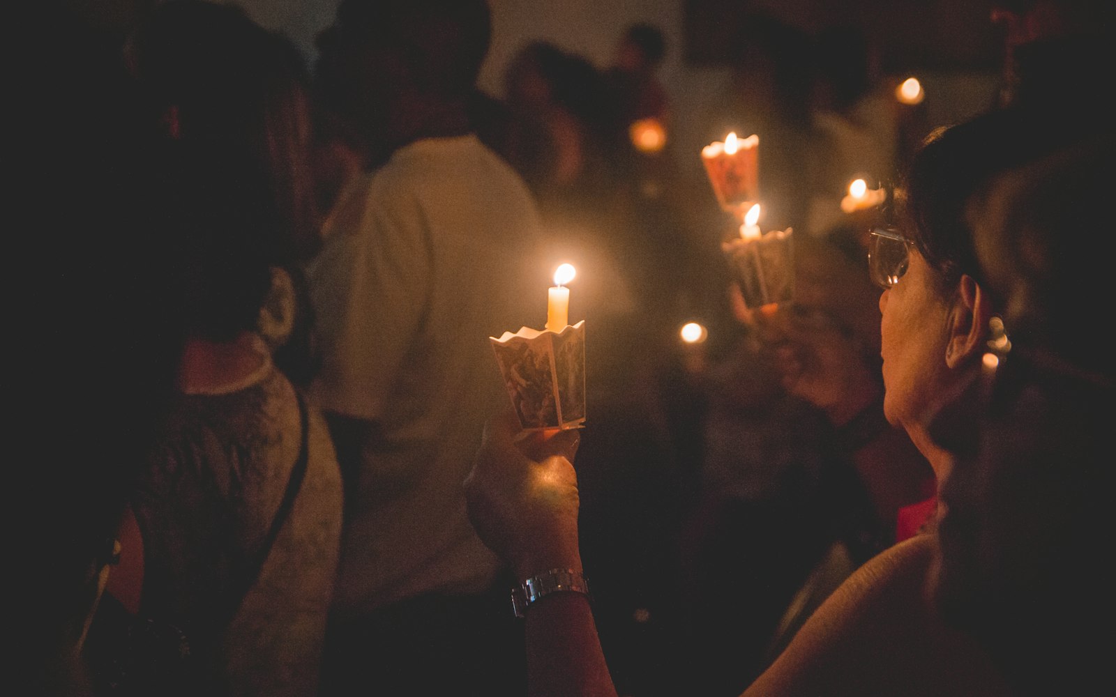 People holding lighted candles during nighttime