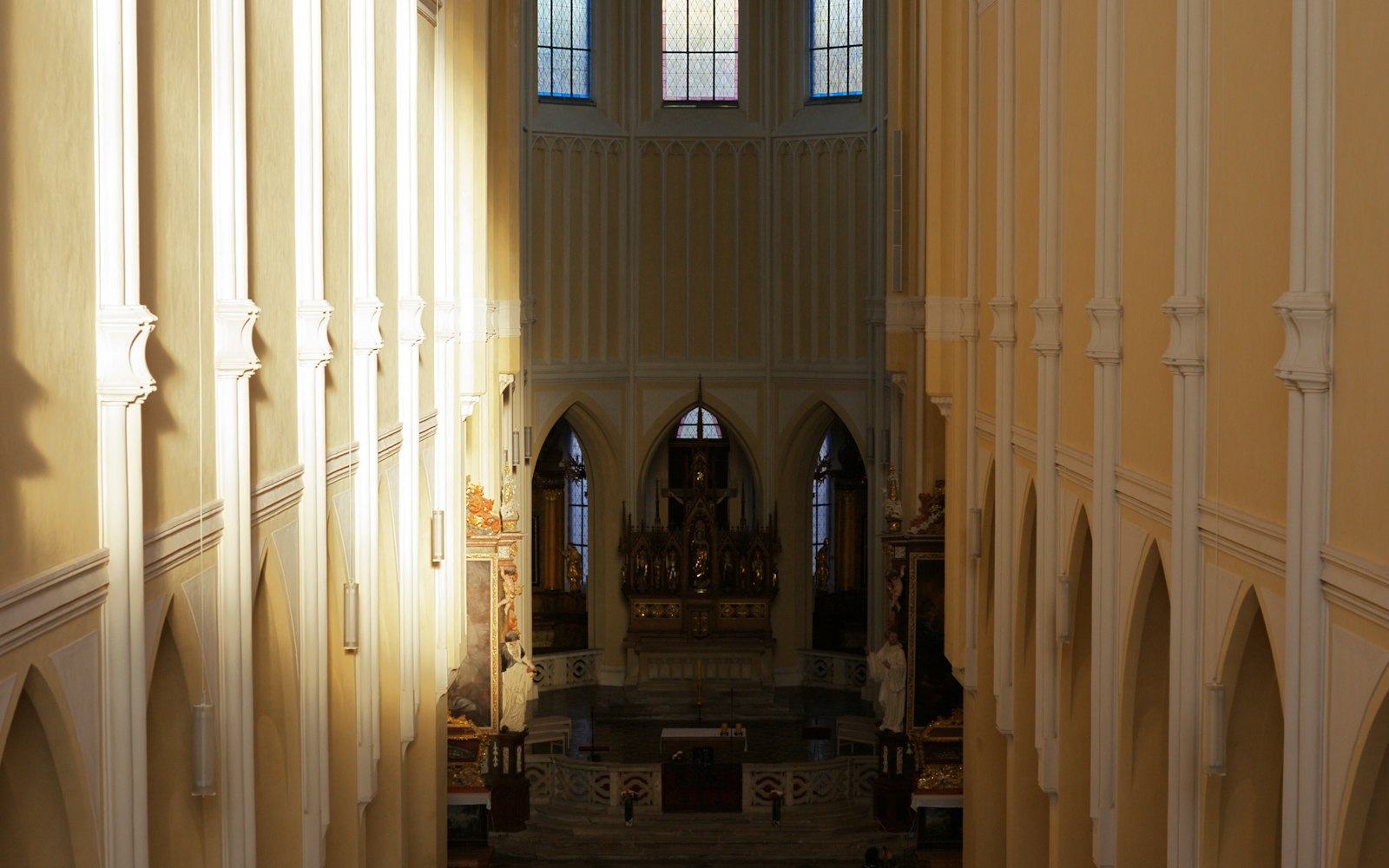 Sunlight streams into a grand church interior, illuminating the nave and pews